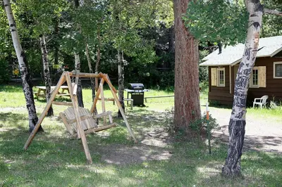 a wooden swing set in a yard with trees at Triple R Cottages- 4 cabin in Estes Park