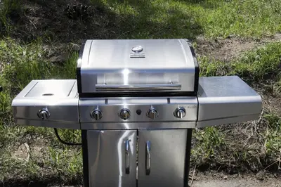 a gas grill sitting on the grass in the yard at Triple R Cottages- 4 cabin in Estes Park