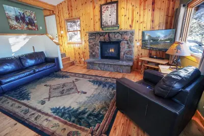 a living room with a couch and a fireplace at Lazy R Cottages- 14 cabin in Estes Park