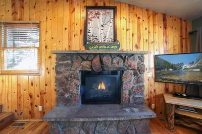 a living room with a fireplace and a tv at Lazy R Cottages- 14 cabin in Estes Park