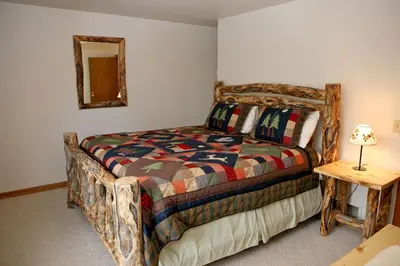 a bedroom with a bed and a table with a lamp at Lazy R Cottages- 14 cabin in Estes Park