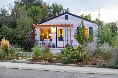 a small house with a garden in front of it at Private Bungalow with Kids Playset in Denver