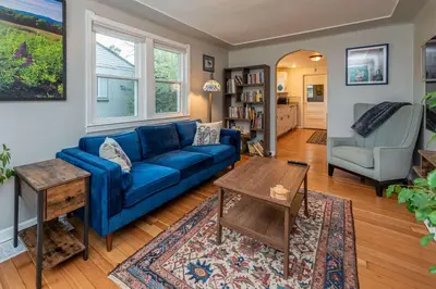 a living room with a blue couch and a table at Private Bungalow with Kids Playset in Denver