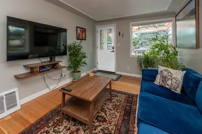 a living room with a blue couch and a table at Private Bungalow with Kids Playset in Denver