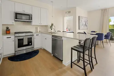a kitchen with white cabinets and a table with chairs at Heart of Olde Town - Urban Retreat - 95 Walk Score in Arvada
