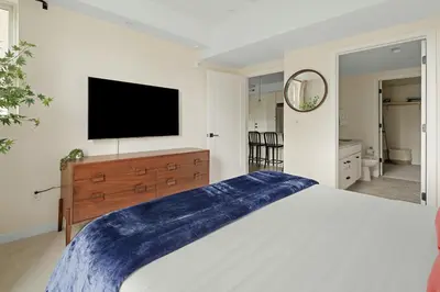 a bedroom with a large bed and a flat screen tv at Heart of Olde Town - Urban Retreat - 95 Walk Score in Arvada