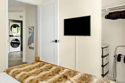 a bedroom with a bed and a flat screen tv on a wall at Heart of Olde Town - Urban Retreat - 95 Walk Score in Arvada