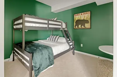 a bedroom with a bunk bed and a green wall at Heart of Olde Town - Urban Retreat - 95 Walk Score in Arvada