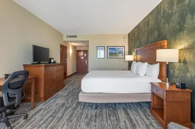 a hotel room with a bed and a desk and a computer at Drury Plaza Hotel Denver Central Park in Denver