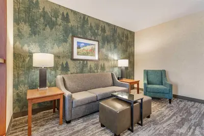 a living room with a couch and a chair at Drury Plaza Hotel Denver Central Park in Denver