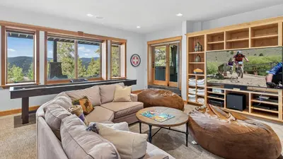 a living room with a couch and a tv at Moose Tracks Lodge in Breckenridge