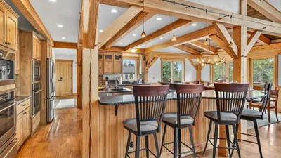 a kitchen with wooden cabinets and a bar with stools at Moose Tracks Lodge in Breckenridge