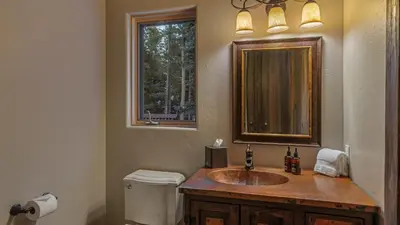 a bathroom with a sink and a mirror and a toilet at Alpenglow Peaks Lodge in Breckenridge