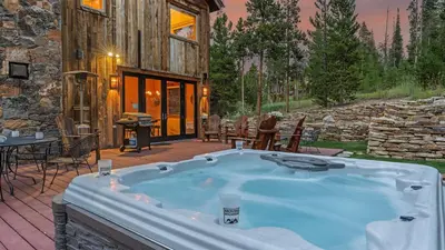 a jacuzzi tub in the backyard of a log cabin at Alpenglow Peaks Lodge in Breckenridge