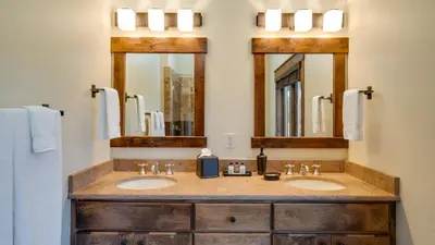a bathroom with two sinks and two mirrors at Blue Skies at The Shores in Breckenridge