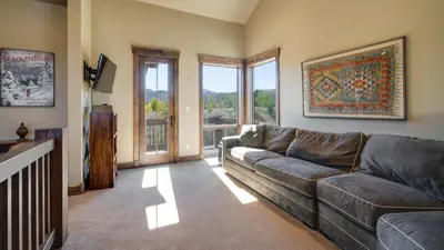 a living room with a leather couch and a large window at Blue Skies at The Shores in Breckenridge