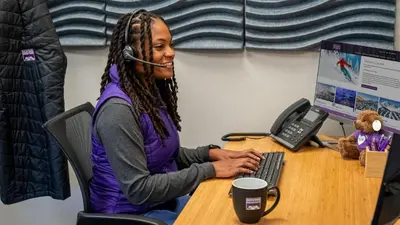 a woman sitting at a desk with a headset at Blue Skies at The Shores in Breckenridge