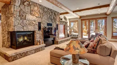 a living room with a large stone fireplace at Point View Place in Breckenridge