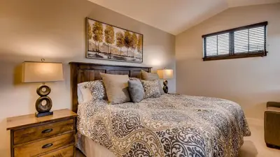a bedroom with a bed and a dresser and a window at River Song at The Shores in Breckenridge