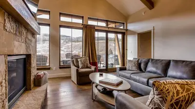 a living room with a couch and a fireplace at River Song at The Shores in Breckenridge