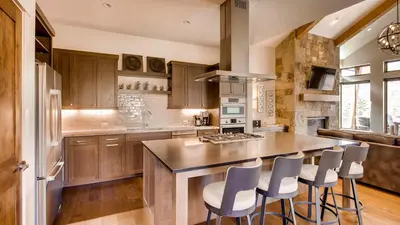 a kitchen with a island with bar stools at River Song at The Shores in Breckenridge