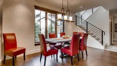 a dining room with a table and red chairs at River Song at The Shores in Breckenridge