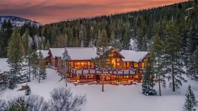 a log cabin in the snow with lights on at Winterfell Estates in Breckenridge