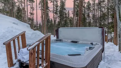 a hot tub on a deck in the snow at Cypress Mountain Chalet in Breckenridge