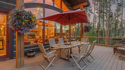 a patio with a table and chairs and an umbrella at Cypress Mountain Chalet in Breckenridge