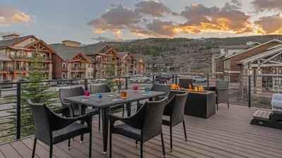 a patio with a table and chairs on a deck at On the Corner at The Shores in Breckenridge