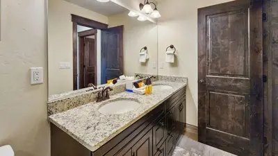 a bathroom with two sinks and a wooden door at 4BD Family Friendly Minutes from River Run Gondola in Keystone