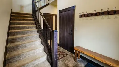 a staircase with a wooden door and a wooden bench at 4BD Family Friendly Minutes from River Run Gondola in Keystone