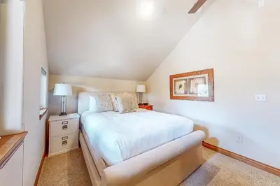 a white bedroom with a bed and a lamp at Blue River Grove in Silverthorne
