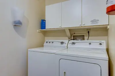 a white washing machine in a kitchen with white cabinets at Spacious Aurora Retreat with Game Room and Hot Tub! in Aurora