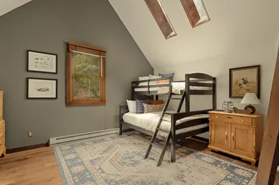a bedroom with two bunk beds and a rug at Stunning View House - 15-min to Town - Evergreen in Evergreen