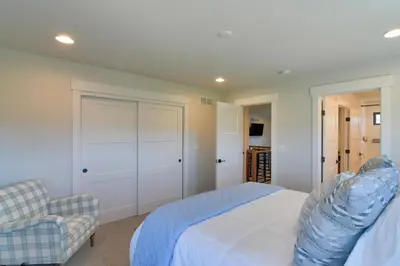 a bedroom with a white bed and a chair at Colorado Home with Hot Tub! Close to Ski Resorts in Granby