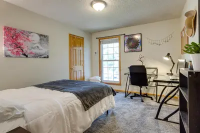 a bedroom with a bed and a desk and a window at Furnished Deck and Fire Pit Thornton Family Retreat in Thornton