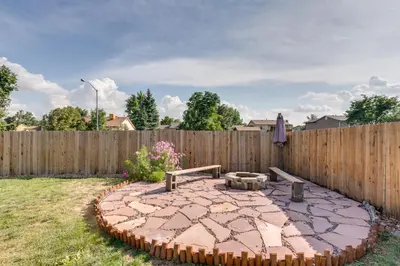 a patio in a backyard with a wooden fence at Furnished Deck and Fire Pit Thornton Family Retreat in Thornton
