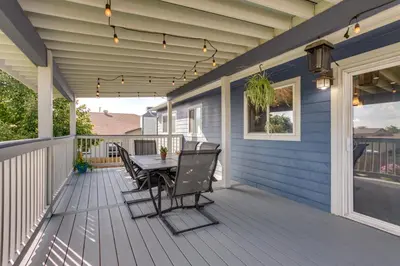 a patio with a table and chairs on a blue house at Furnished Deck and Fire Pit Thornton Family Retreat in Thornton
