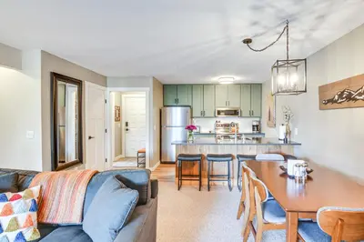 a living room and kitchen with a couch and a table at Elevated Fraser Condo with Mountain View and Amenities in Fraser