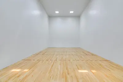 an empty white room with a wooden floor at Elevated Fraser Condo with Mountain View and Amenities in Fraser