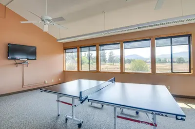 a ping pong table in a room with a tv at Elevated Fraser Condo with Mountain View and Amenities in Fraser