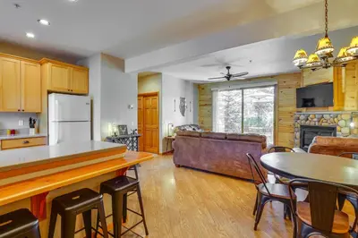 a kitchen and living room with a table and a couch at Walk to Main Street Grand Lake Condo with Patio in Grand Lake