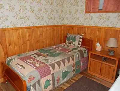 a bedroom with a bed with a quilt on it at Wapiti Retreat at 22 West Cabins and Recreation in Walden