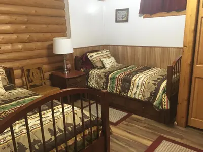 a bedroom with two beds and a table with a lamp at Wapiti Retreat at 22 West Cabins and Recreation in Walden