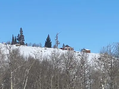 a house on top of a snow covered hill at Red-tail Roundhouse at 22 West Cabins and Recreation in Hebron