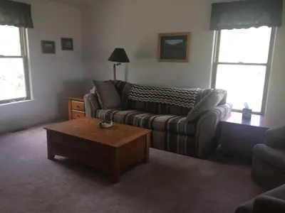 a living room with a couch and a coffee table at Whistle Pig Retreat at 22 West Cabins and Recreation in Hebron