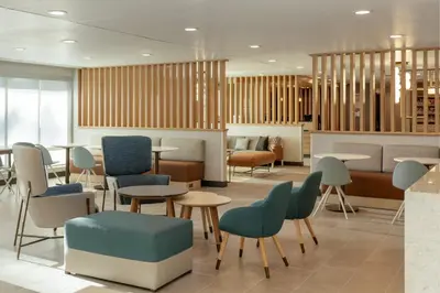 a waiting area with tables and chairs in a lobby at TownePlace Suites by Marriott Denver North Thornton in Thornton