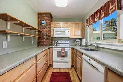 a kitchen with wooden cabinets and white appliances at Your Vacation House ---EV#3216 home in Estes Park