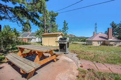 a picnic table and a stove in a yard at Your Vacation House ---EV#3216 home in Estes Park